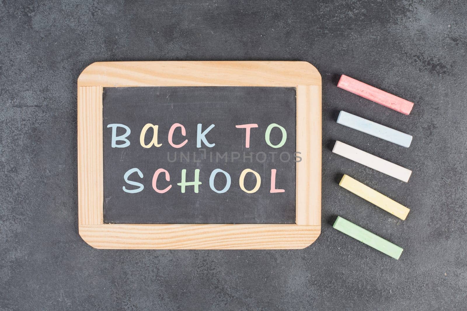 Chalkboard with the text back to school, education concept, colorful chalk