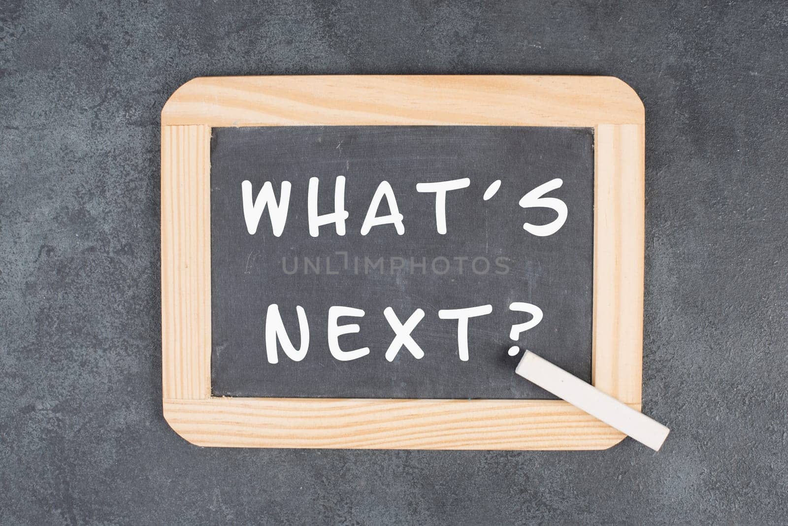 The phrase what´s next is standing on a chalkboard, having new goals and strategies, making plans for future