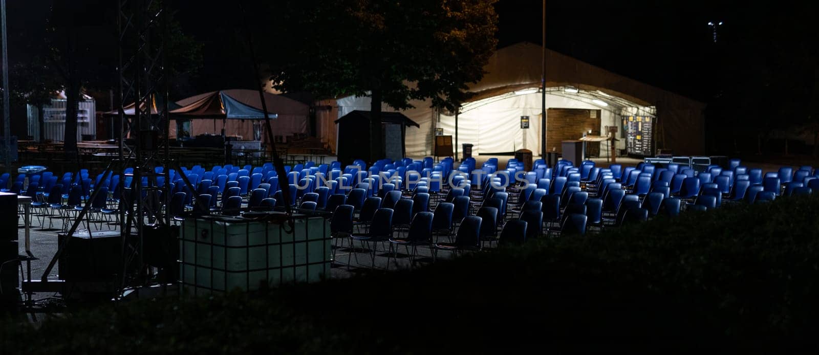desolating rows of empty seats, in a place commonly used for outdoor performances now abandoned and waiting for the end of the pandemic, with the risk of business failure, night scene