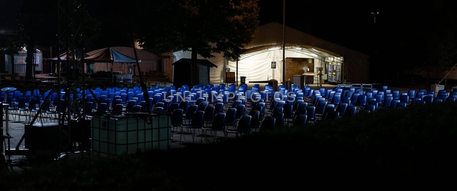desolating rows of empty seats, in a place commonly used for outdoor performances now abandoned and waiting for the end of the pandemic, with the risk of business failure, night scene