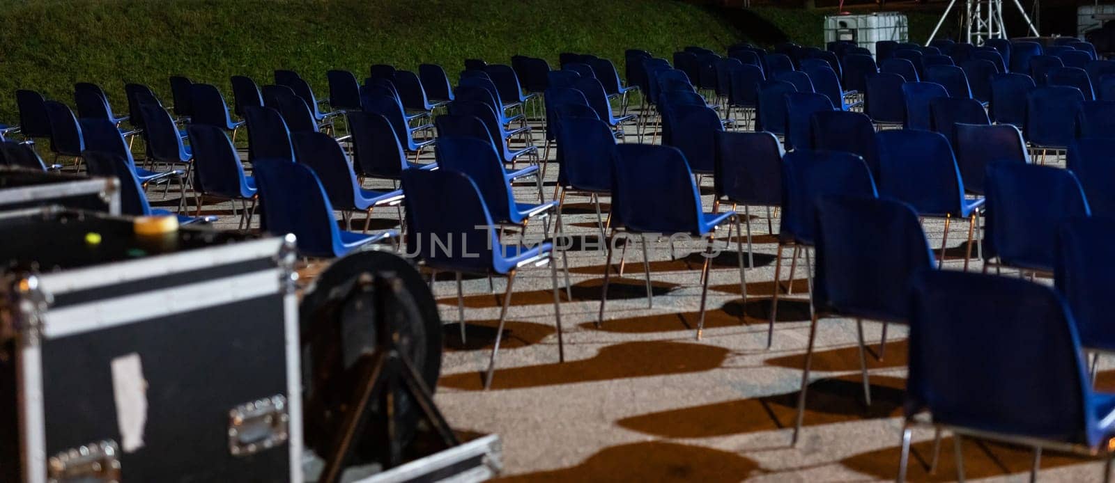 desolating rows of empty seats, in a place commonly used for outdoor performances now abandoned and waiting for the end of the pandemic, with the risk of business failure, night scene