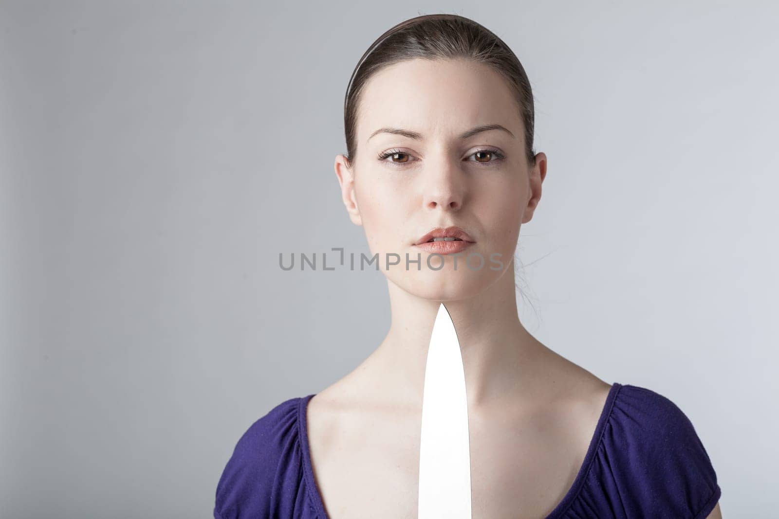 A young woman is playing with a sharp kitchen knife