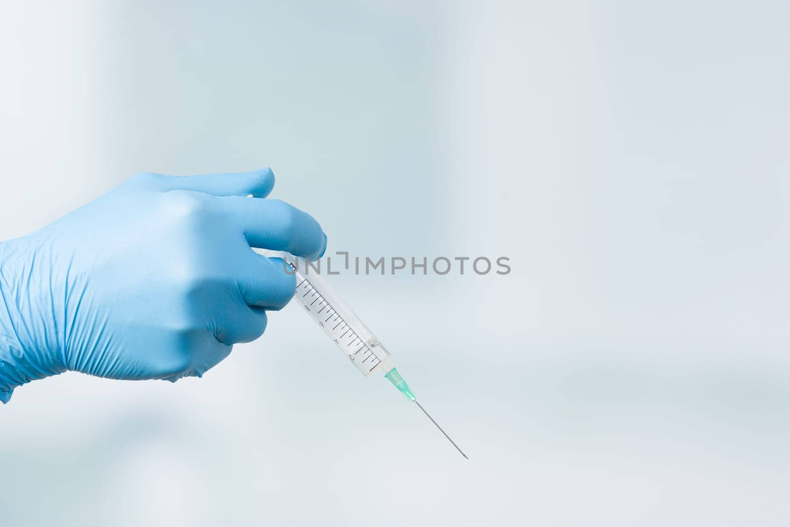 Close up of doctor's hand in medical gloves with a syringe ready for injection