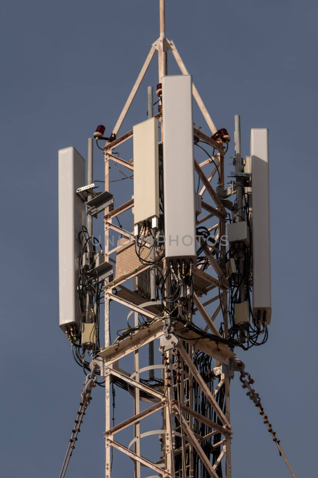 Antenna mast for mobile radio communications in front of a blue sky