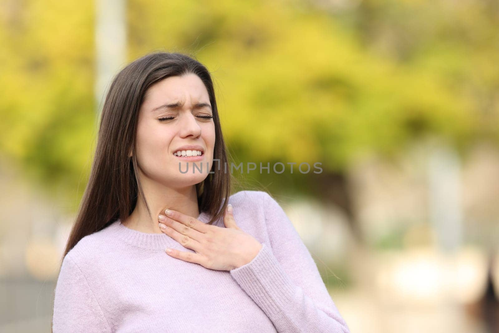 Teen suffering sore throat in a park