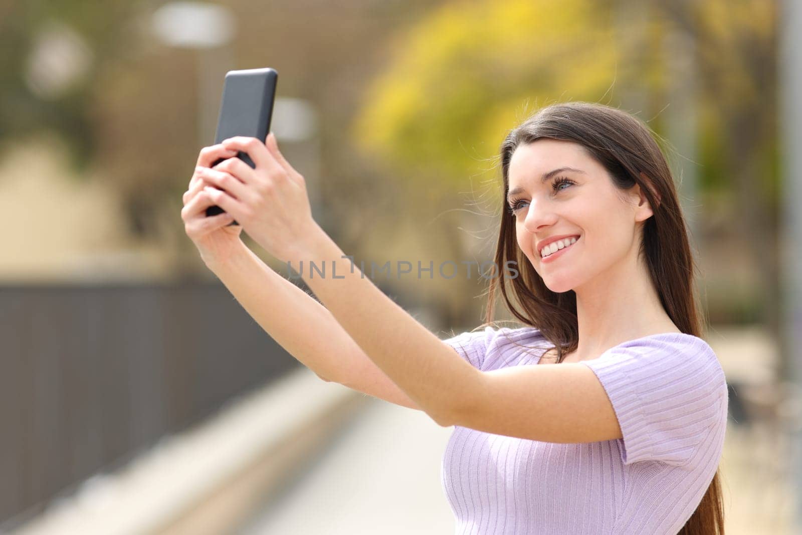 Happy teen taking selfie in a park
