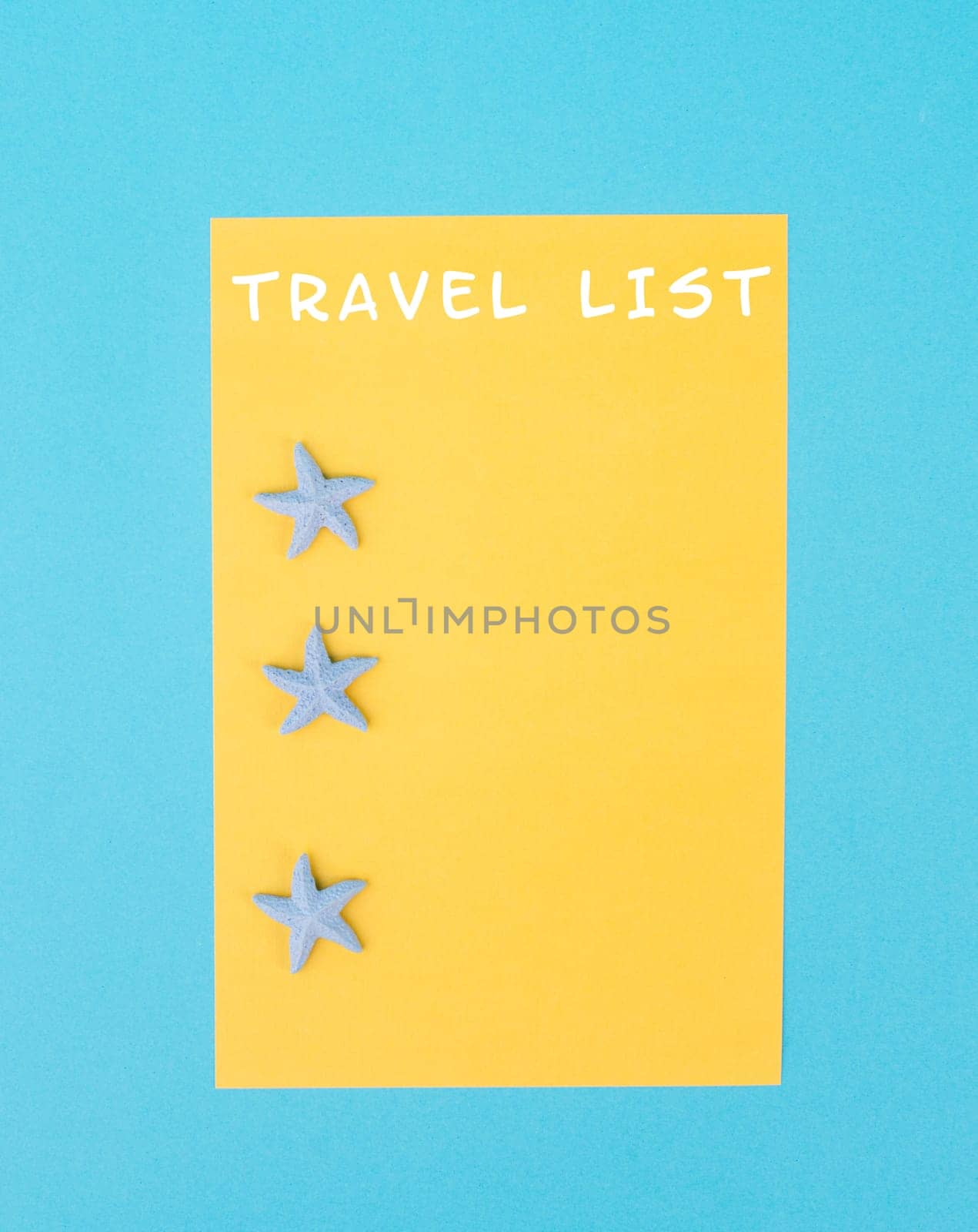 Travel list is standing on the yellow colored paper, sea stars, holiday plan and destination, vacation and lifestyle concept