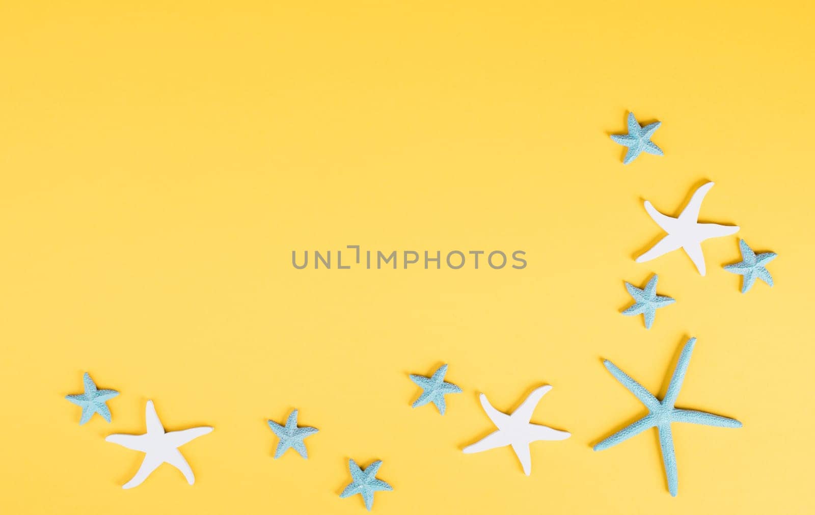 Yellow colored summer and vacation background, anchor and sea stars building a frame, copy space for text, holiday and tourism concept