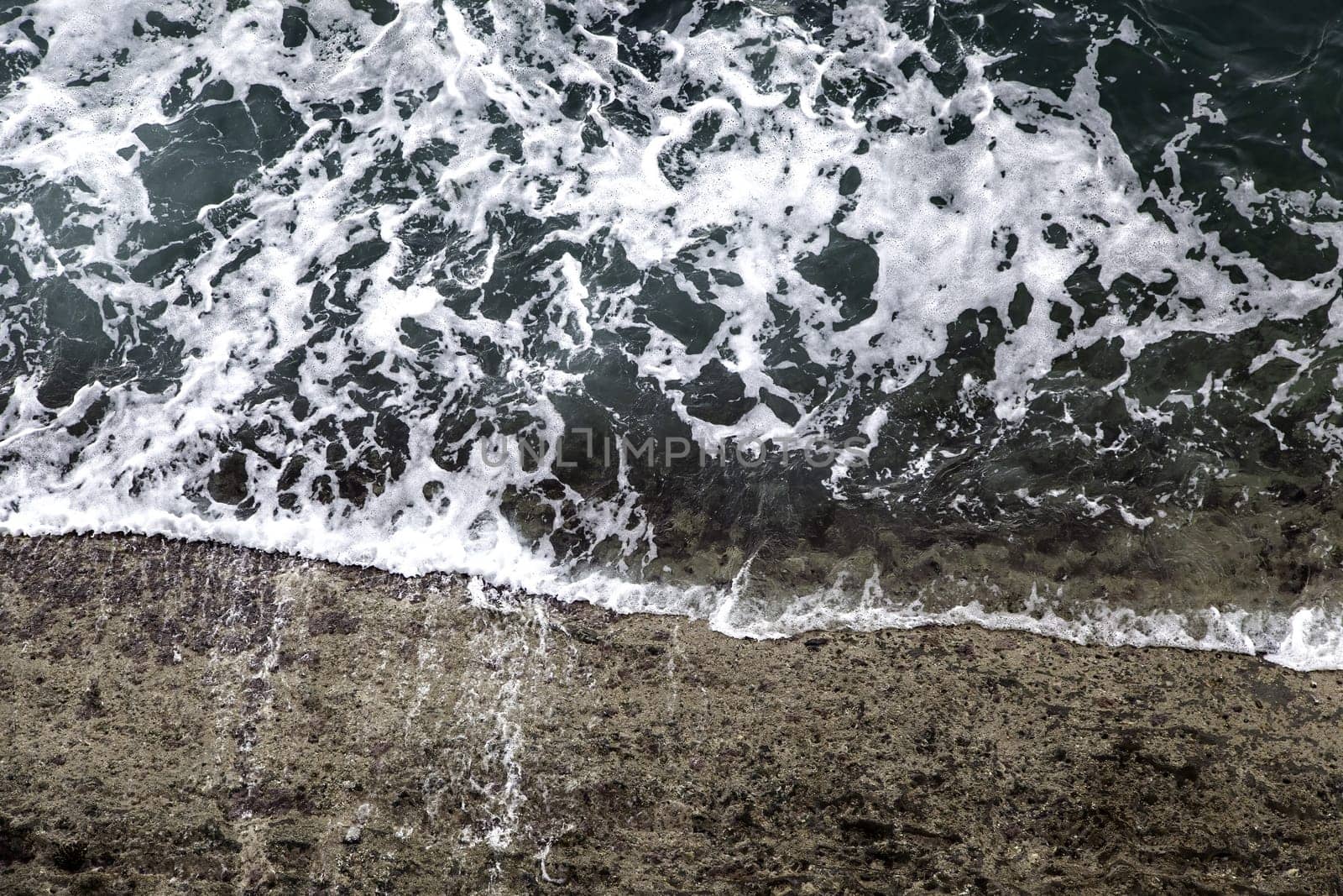 Detail of water waves in the sea, summer day at the beach