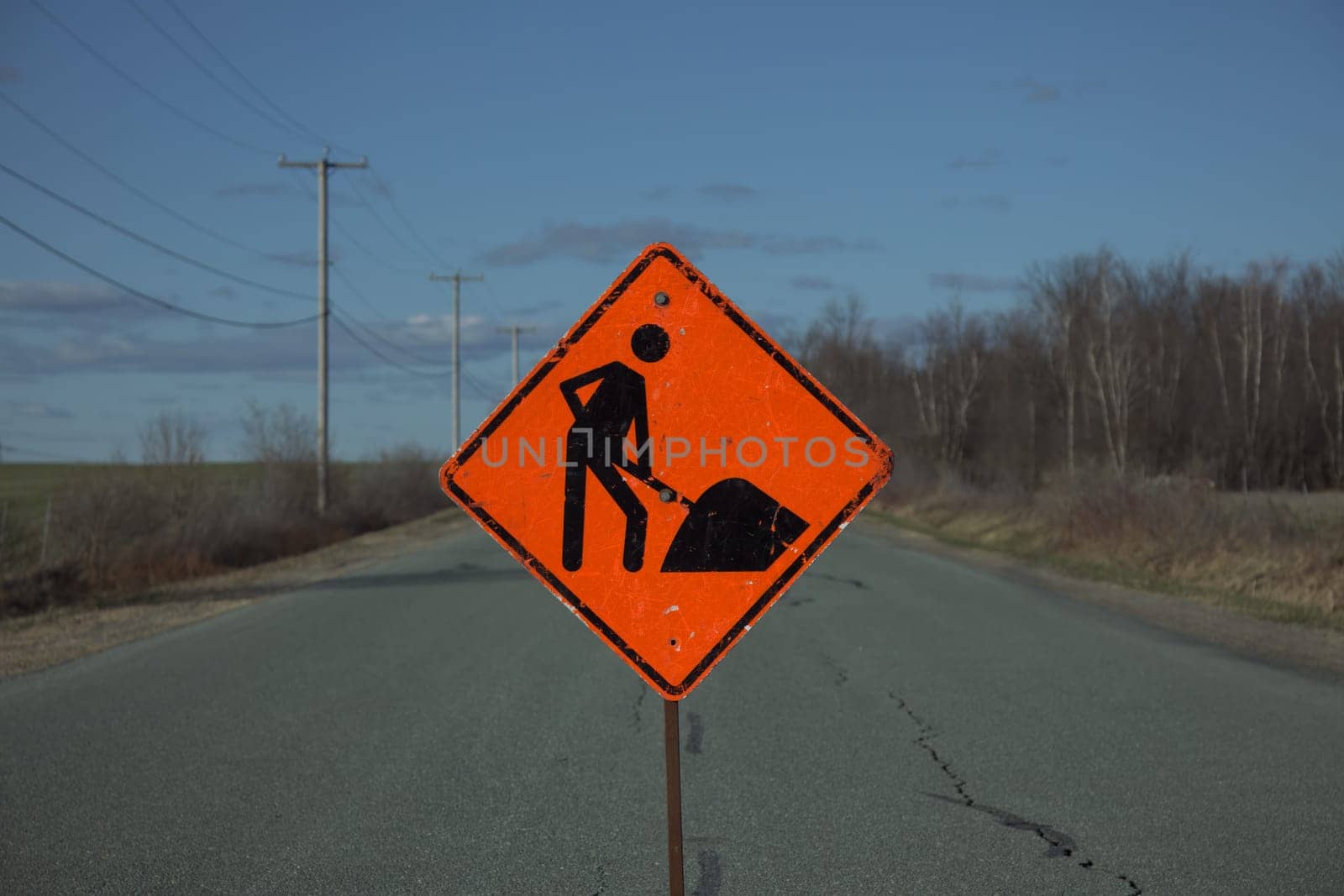 road construction rural street orange traffic sign man at work clouds country sky