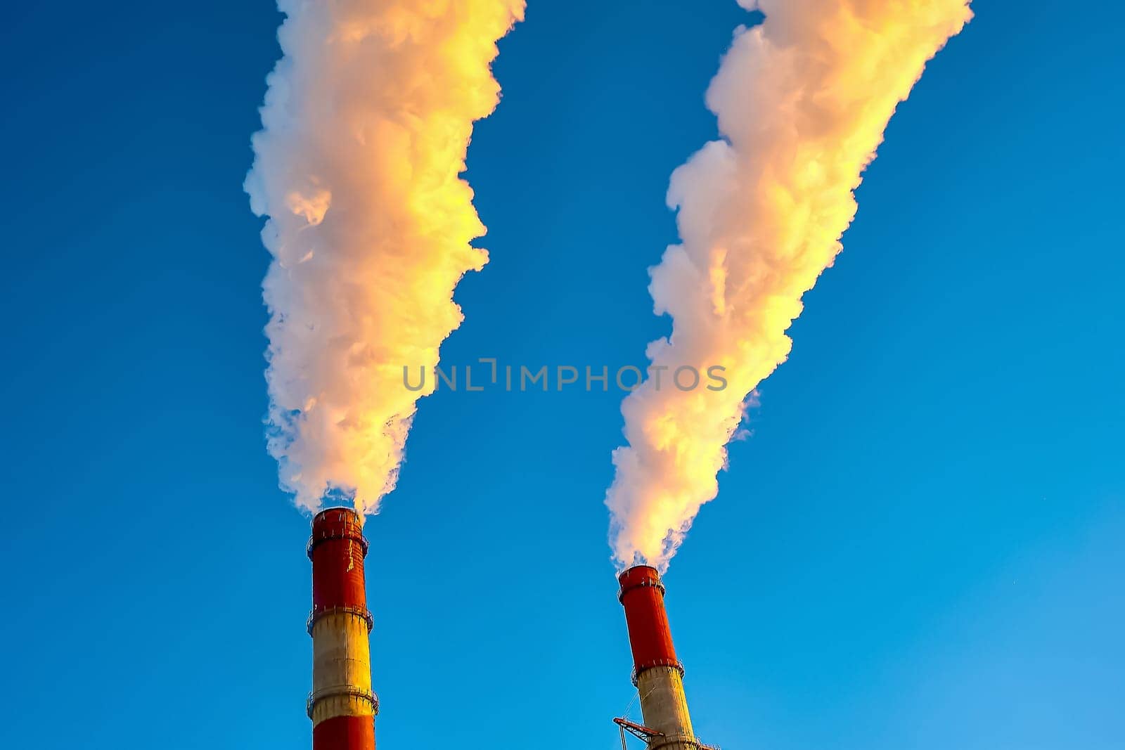 white smoke is coming out of the pipes in the blue sky. High quality photo