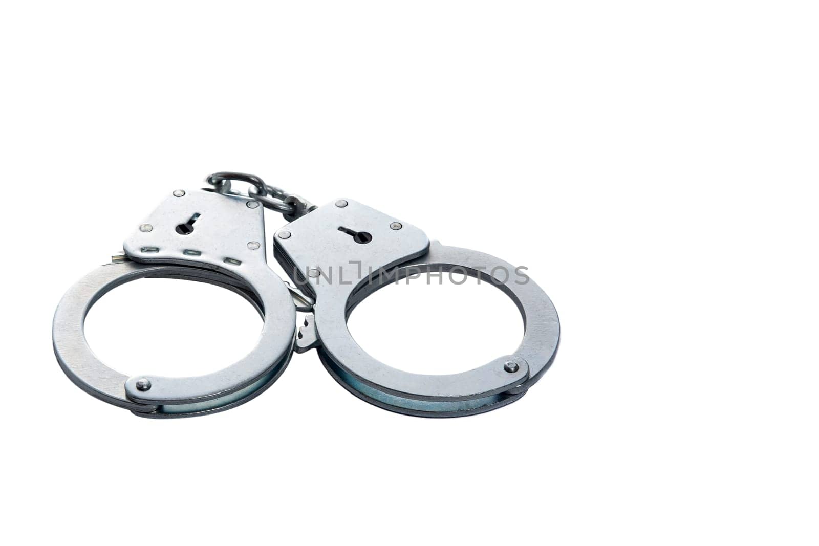 Metal handcuffs on a white isolated background, copy space. High quality photo
