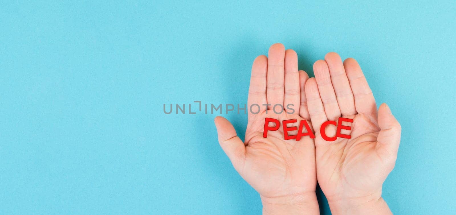 Holding the word peace in the hands, stop war, support Ukraine, living peaceful together