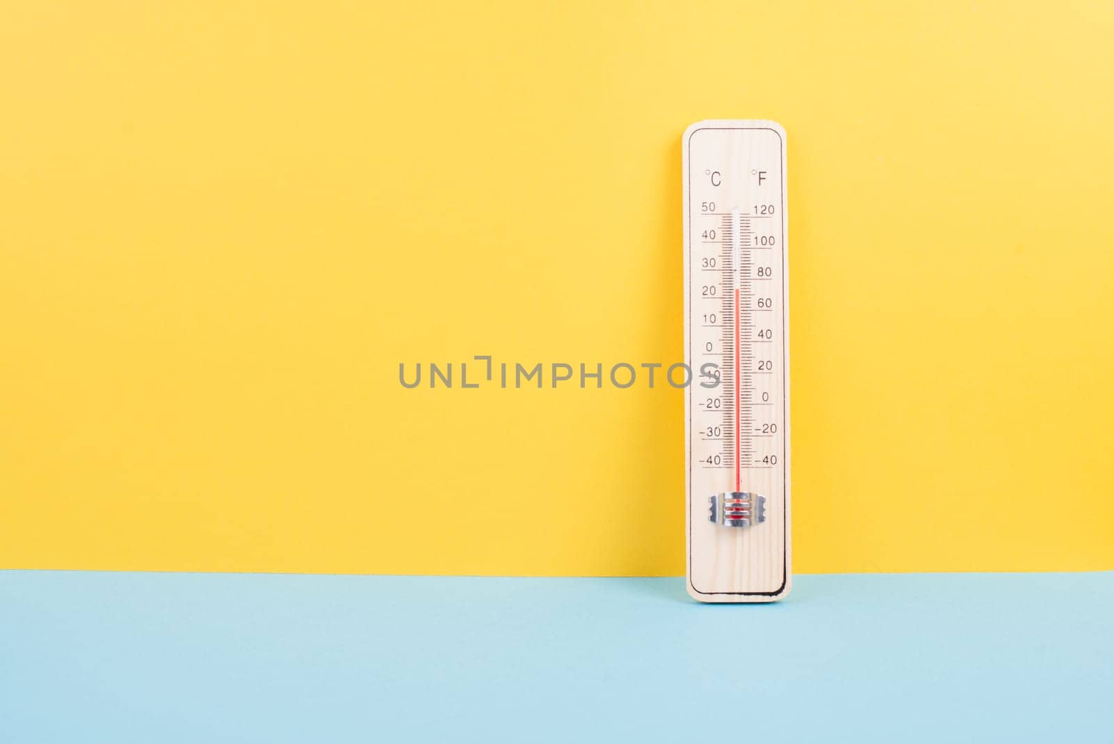 Thermometer on a yellow and blue colored background, measure the temperature, weather forecast, global warming and environment discussion, summer season