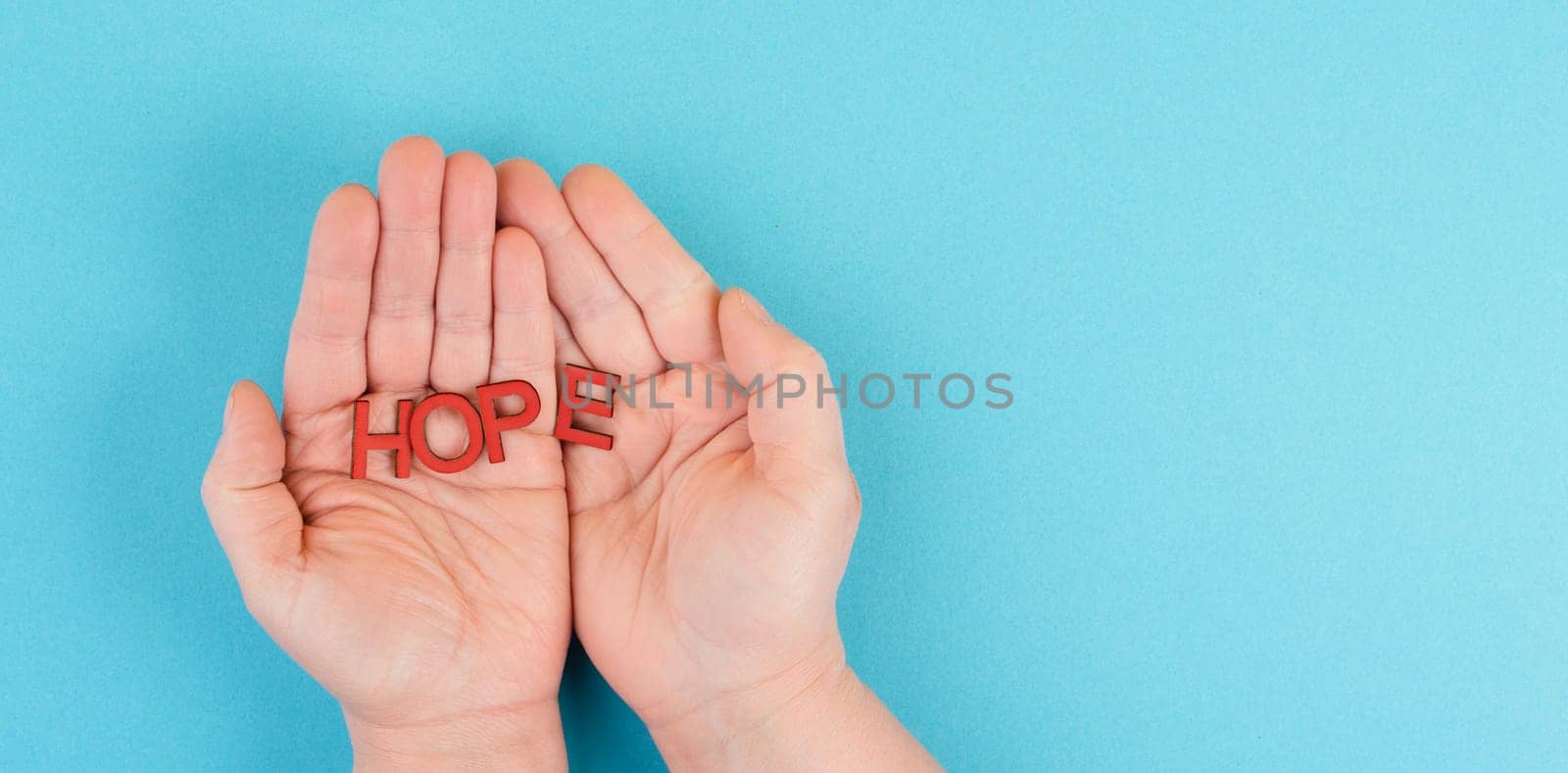 Holding the word hope in the palm of the hands, trust and believe concept, having faith in the future, hopeful positive mindset