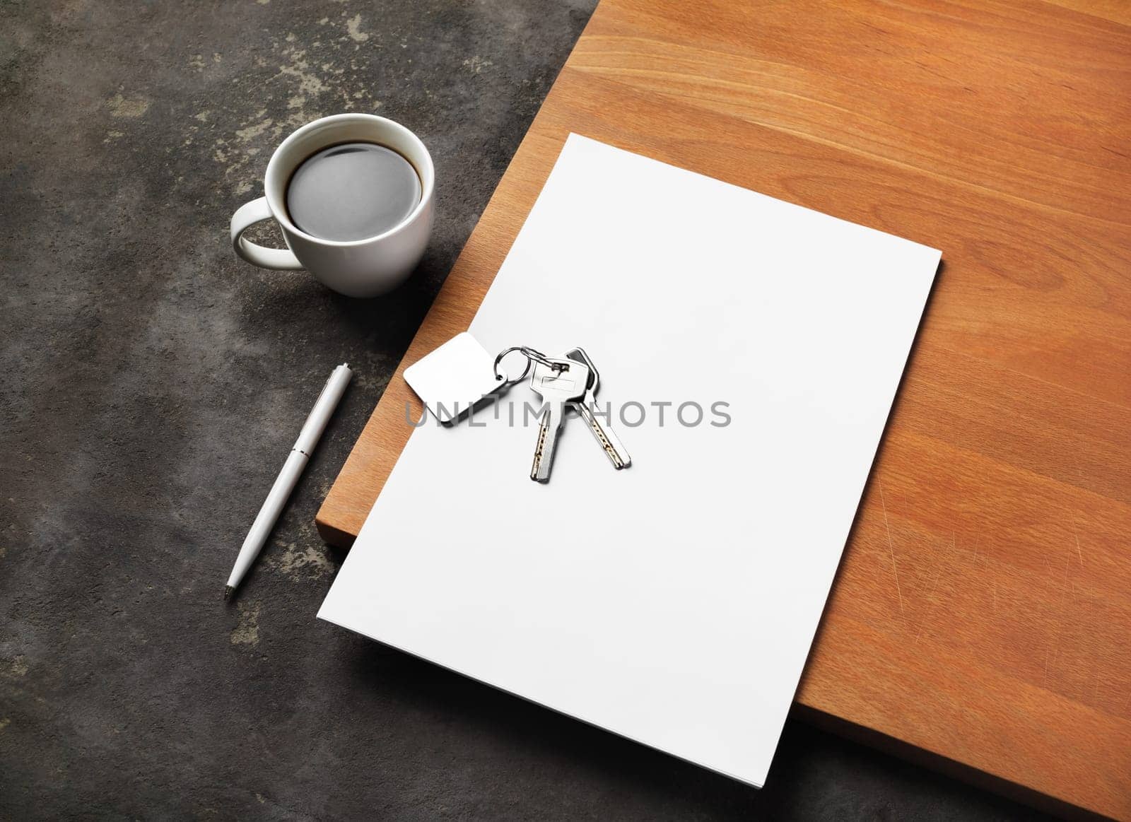Real estate paperwork concept. Blank letterhead, key, coffee cup and pen.