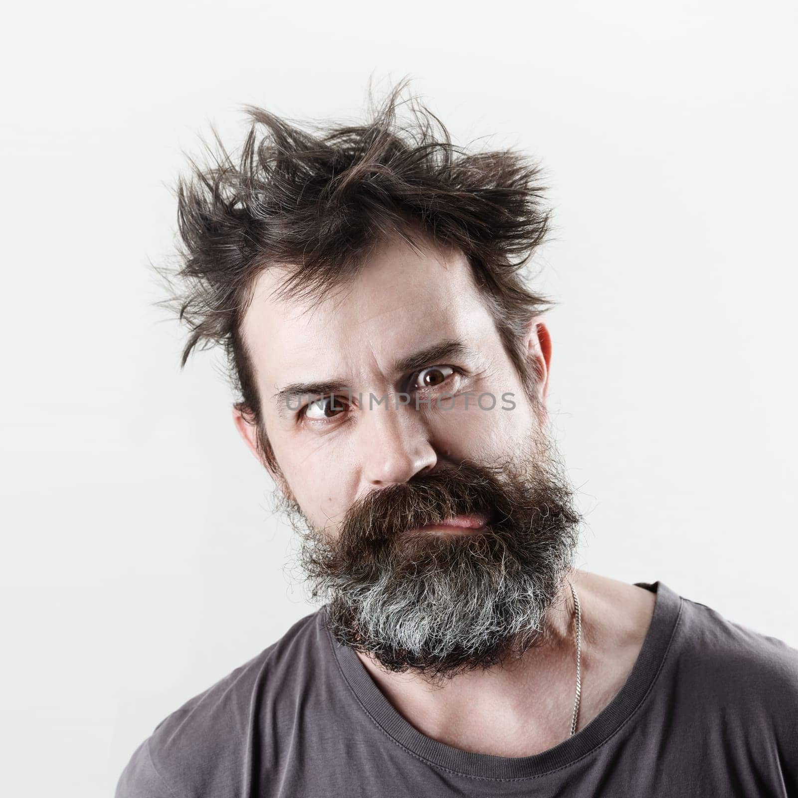 Man with stupid mug. Happy freak bearded shaggy man grimacing and showing tongue.