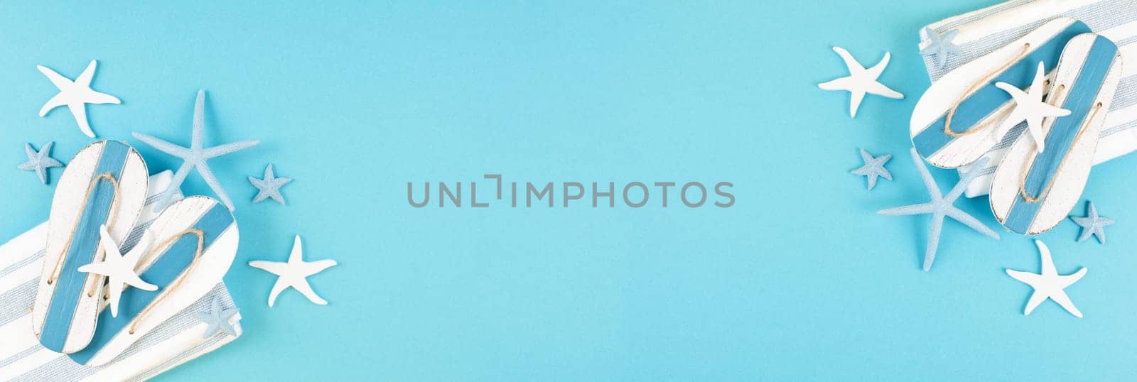 Blue colored summer and vacation background, slippers and sea stars building a frame, copy space for text, holiday and tourism concept