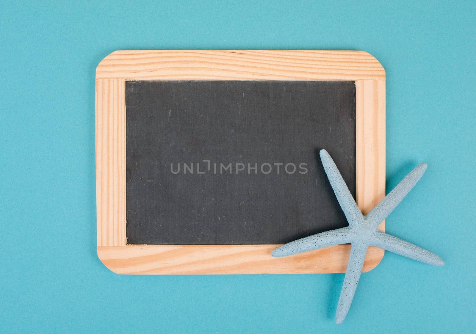 Empty chalkboard with a sea star, holiday background, summer vacation, hot weather, advertising and marketing concept