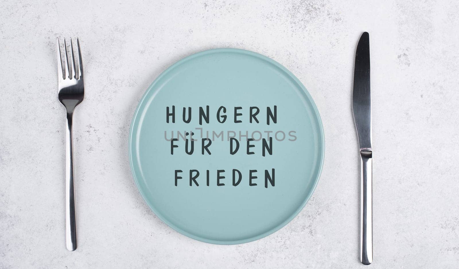 Starve for peace is standing in german language on the empty plate, food shortage because of the war in Ukraine, political issue
