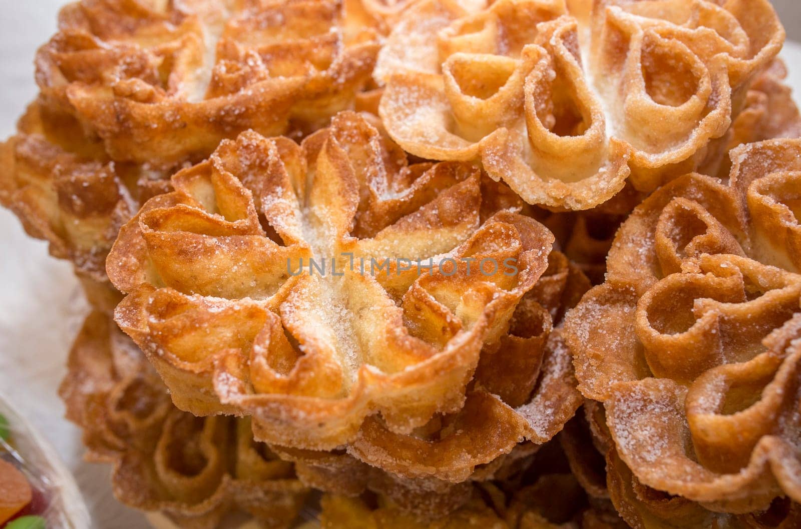 Platter full of traditional fried flores or flowers. Spanish fritter dusted with sugar