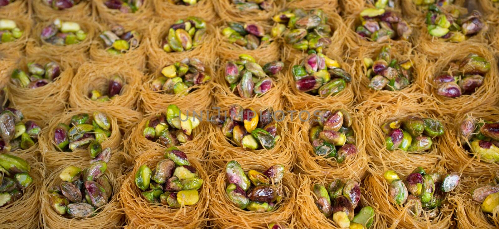 Platter crammed with Nightingales Nests or Ouch El Boulboul. Arabic dessert with pistachio