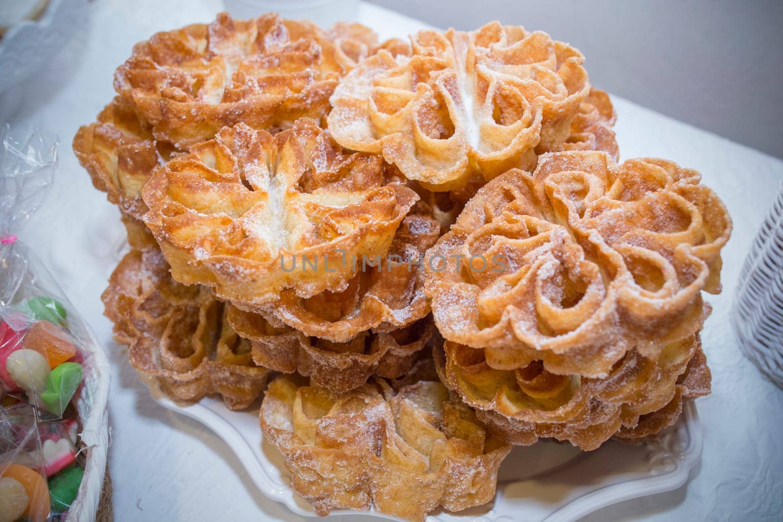 Platter full of traditional fried flores or flowers. Spanish fritter dusted with sugar