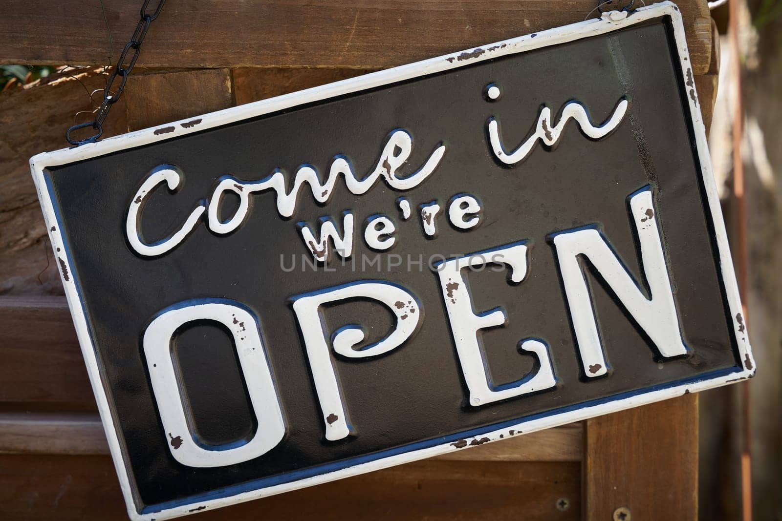 Sign on the front door of a store with the words Come in we are open