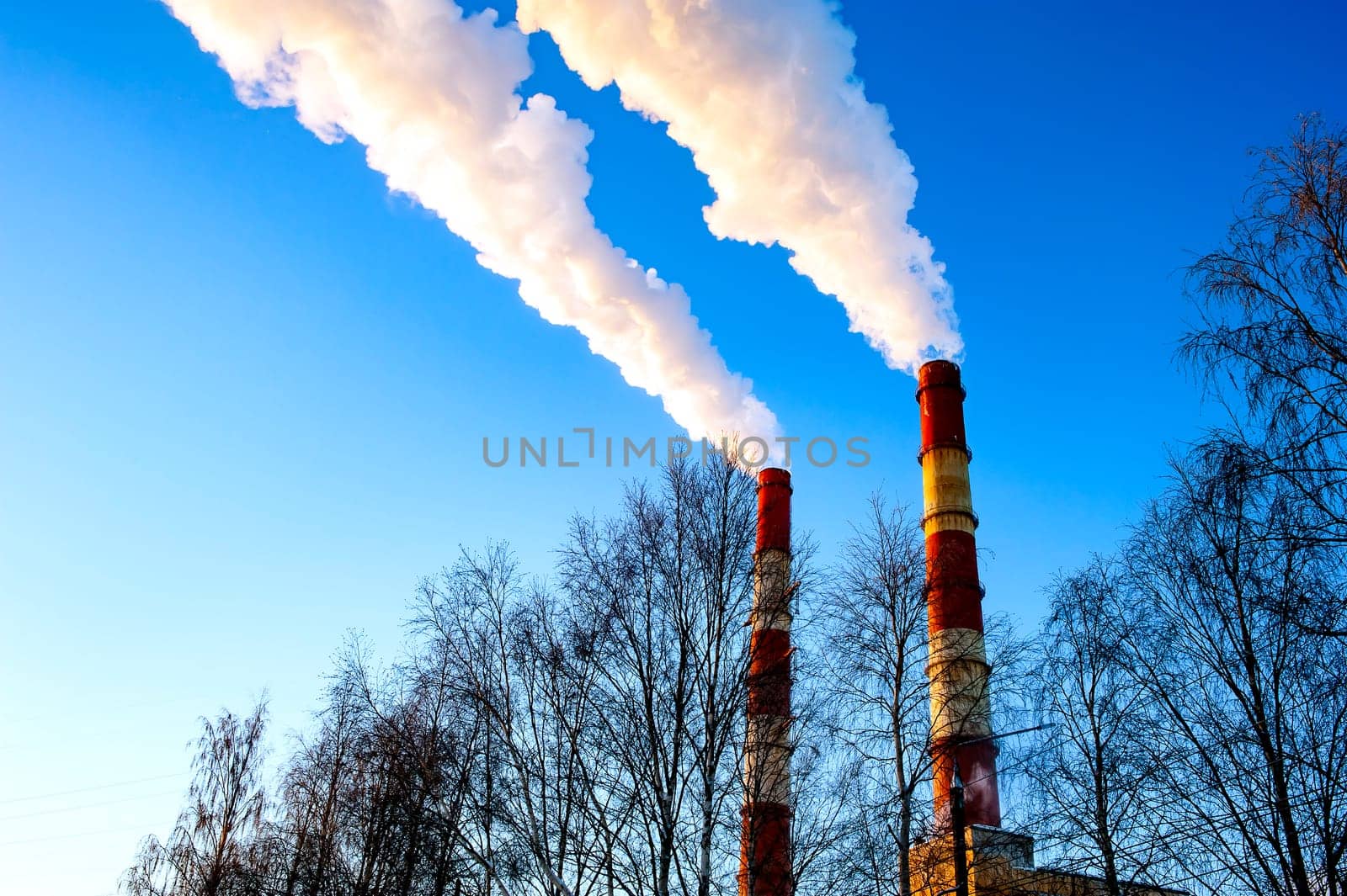 white smoke is coming out of the pipes in the blue sky. High quality photo