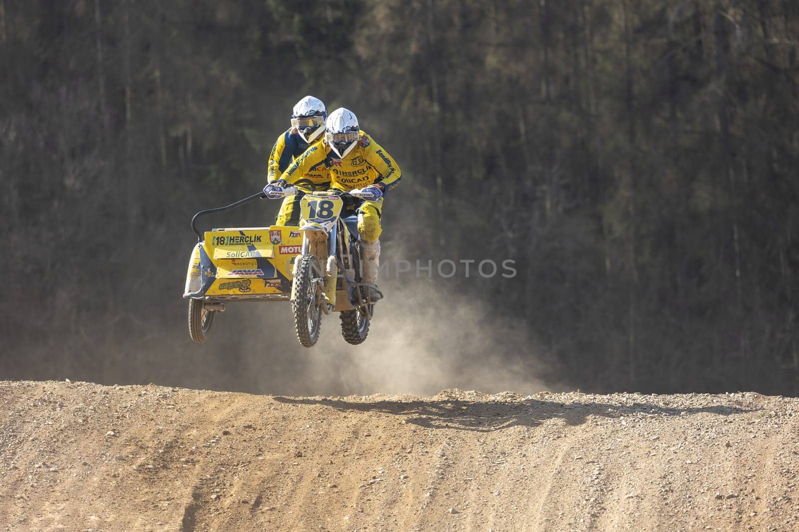 MOHELNICE, CZECH REPUBLIC - APRIL 16, 2022. Sidecacross riders of Herclik team  are jumping with motorbike in the "Sidecarcross Championship of Czech Republic"" on April 16, 2022 in Mohelnice. Czech Republic."
