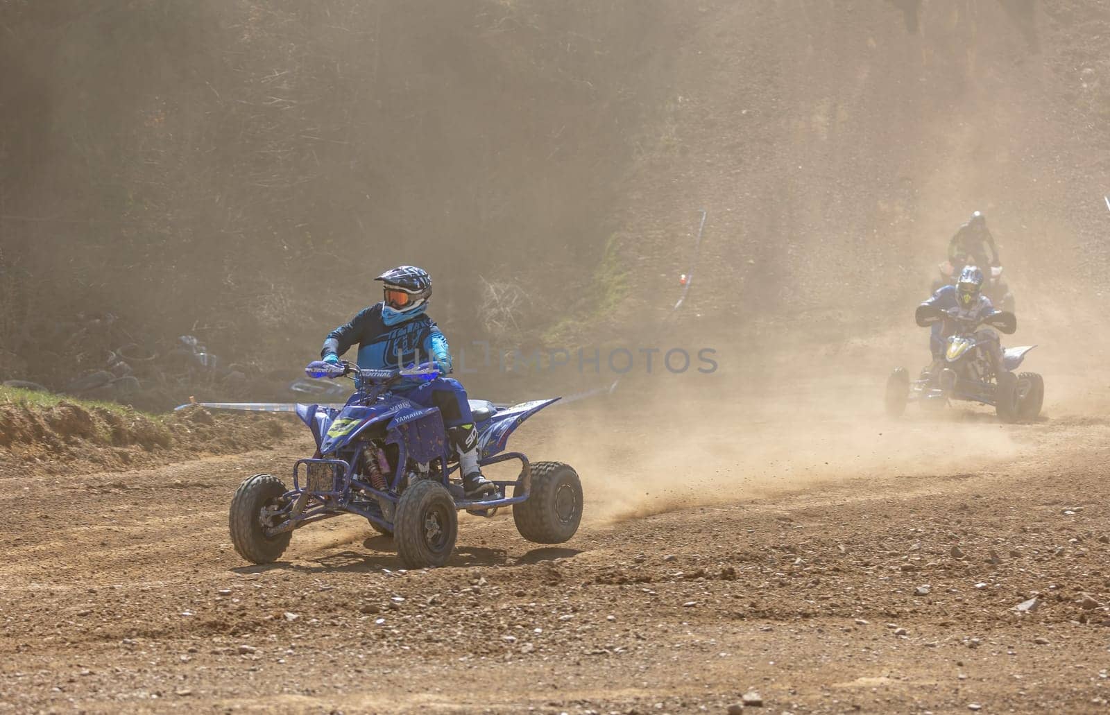 MOHELNICE,  CZECH REPUBLIC - APRIL 16, 2022: Three riders on a quad bike in the dust in International Championship of Czech Republic in Sidecarcross, category Quad on April 16, 2022 in Mohelnice.