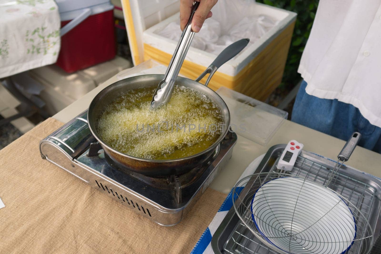Churros are fried in boiling oil in a frying pan. concept COOKING background .