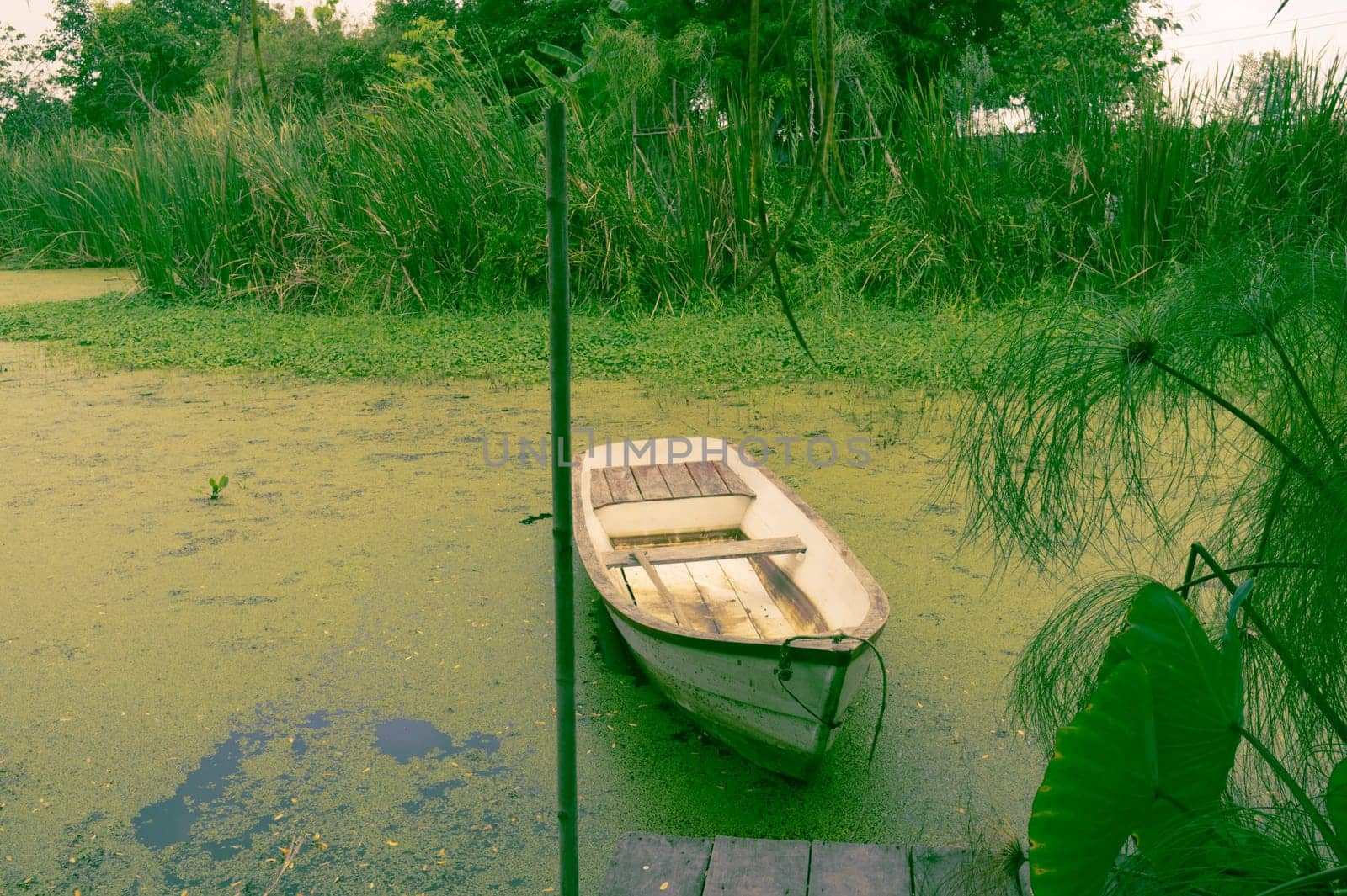 Natural lake landscape with white small fishing boat to the wooden pier