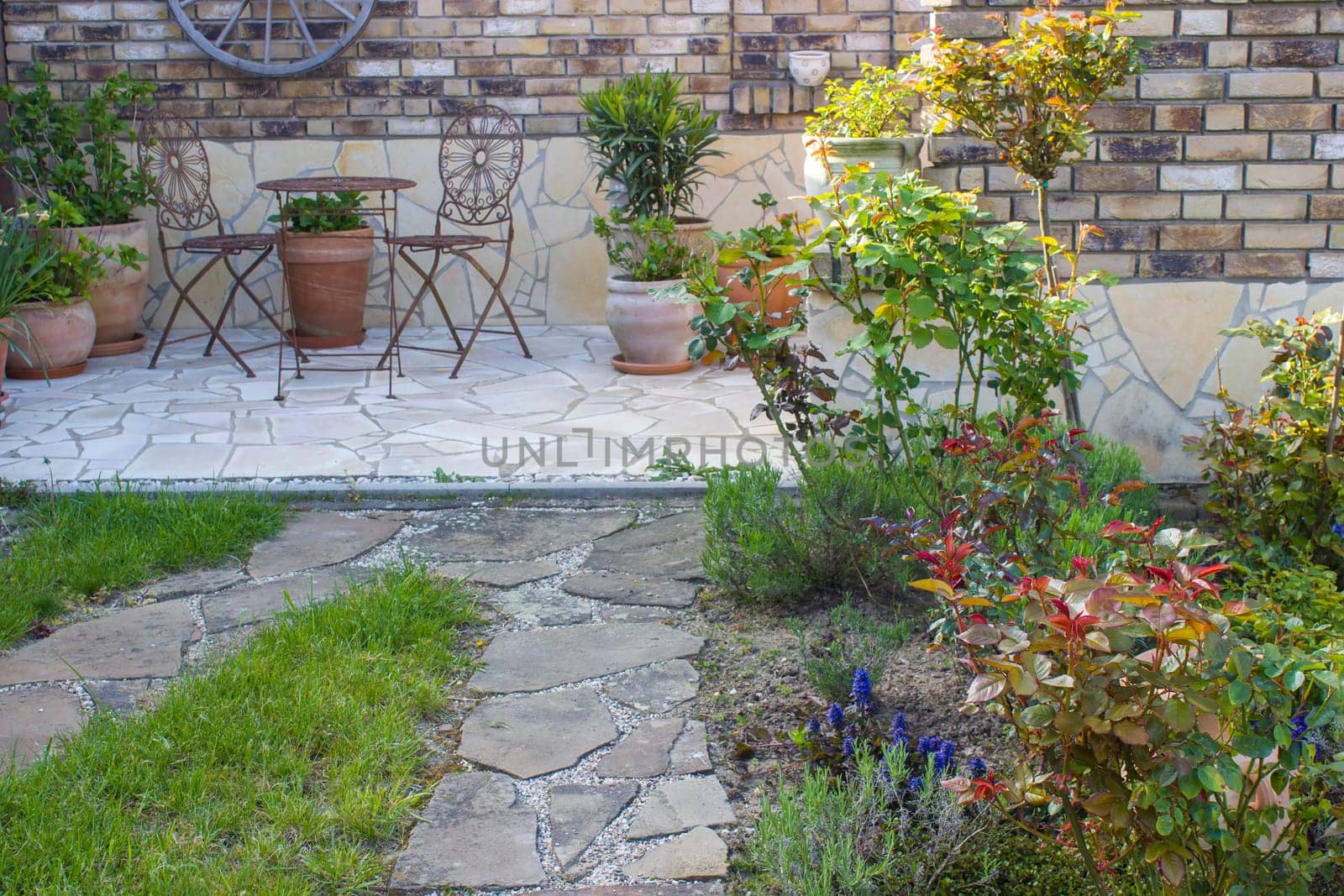beautiful place in the garden in the mediterranean style, brick wall with grill and pots with flowers