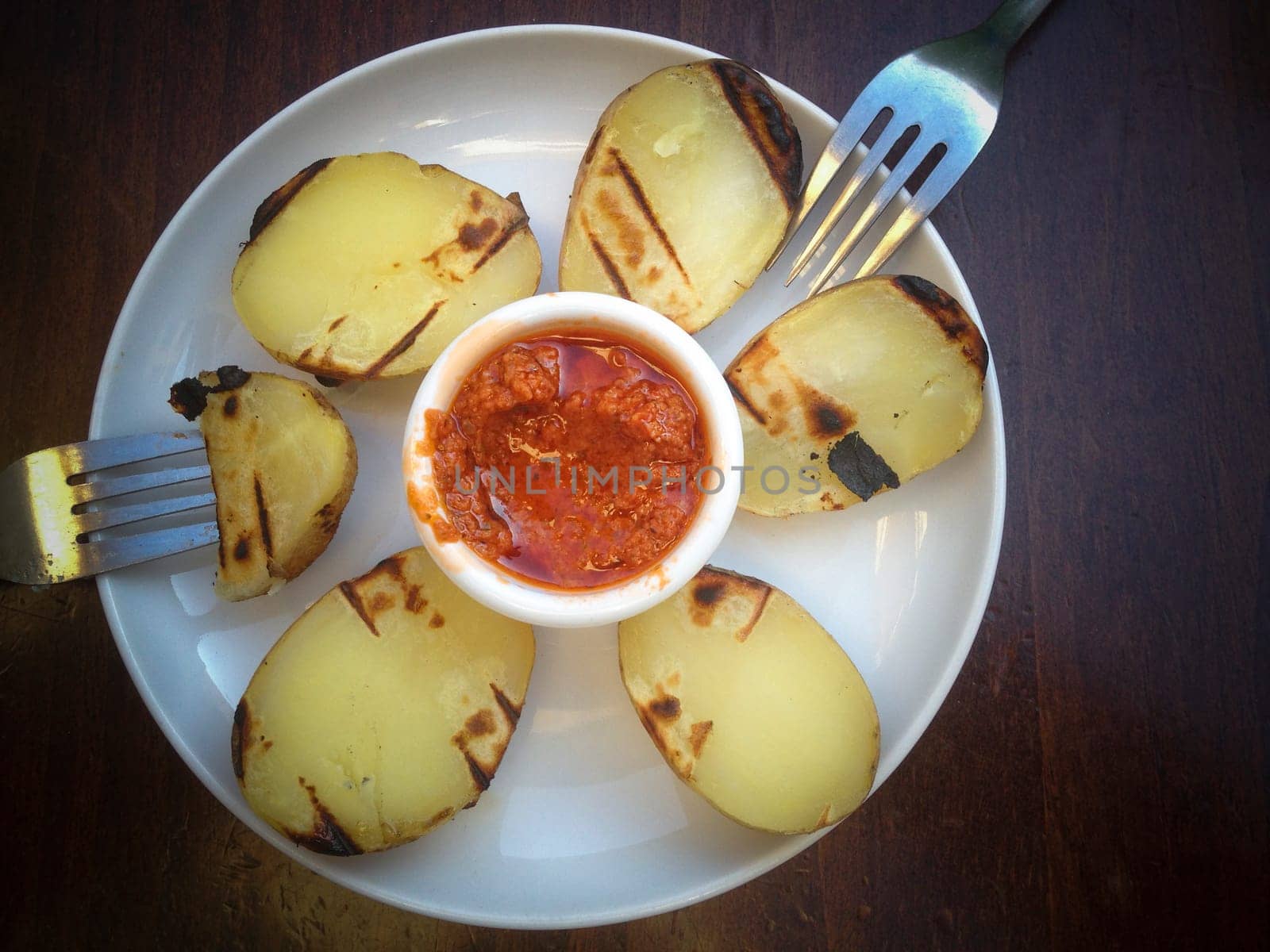 Modern cuisine tapas, roasted potatos with red chimichurri sauce. Overhead view