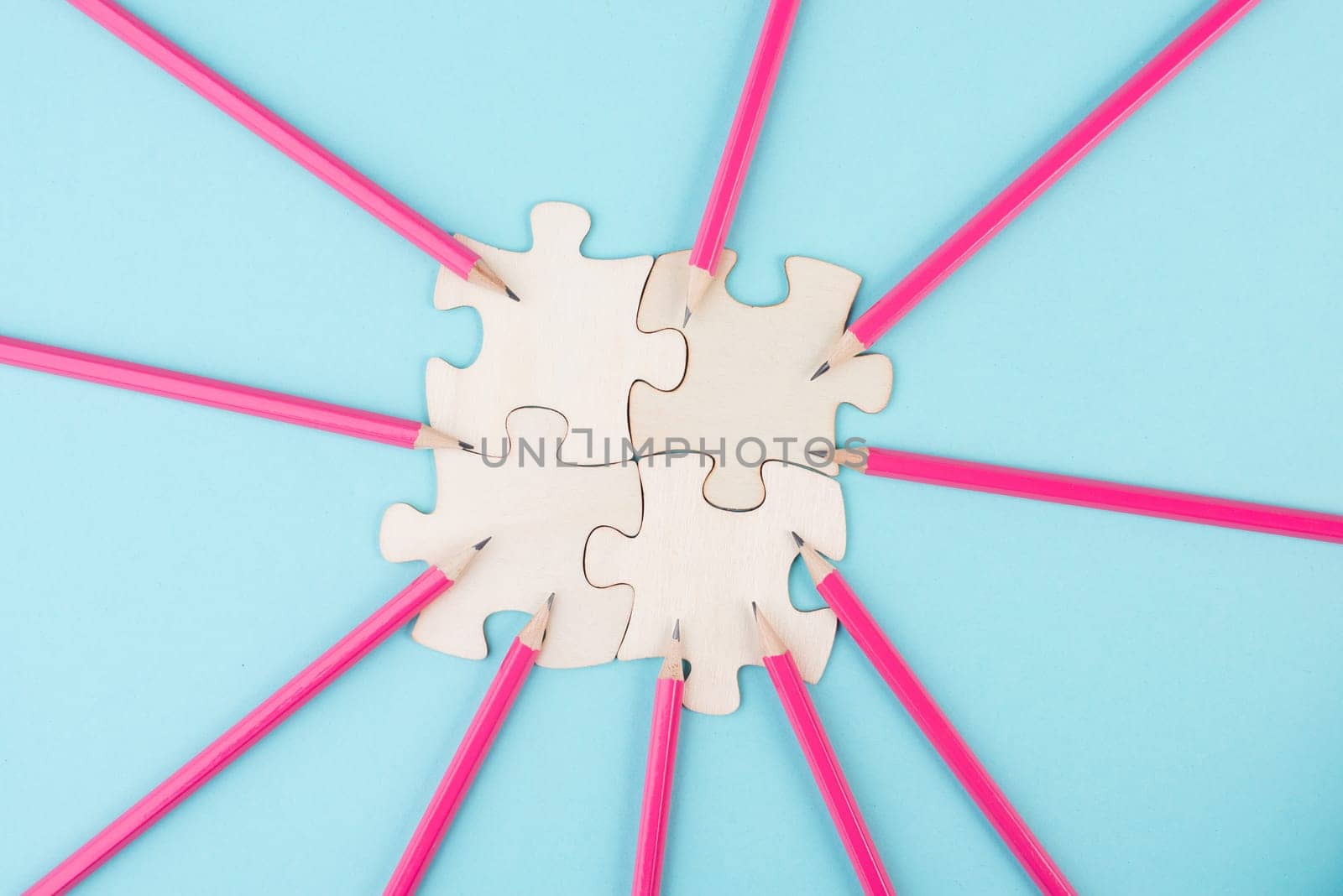 Working as a team, puzzle pieces connect together, pencils point to the jigsaw, brainstorming for ideas, business and education concept