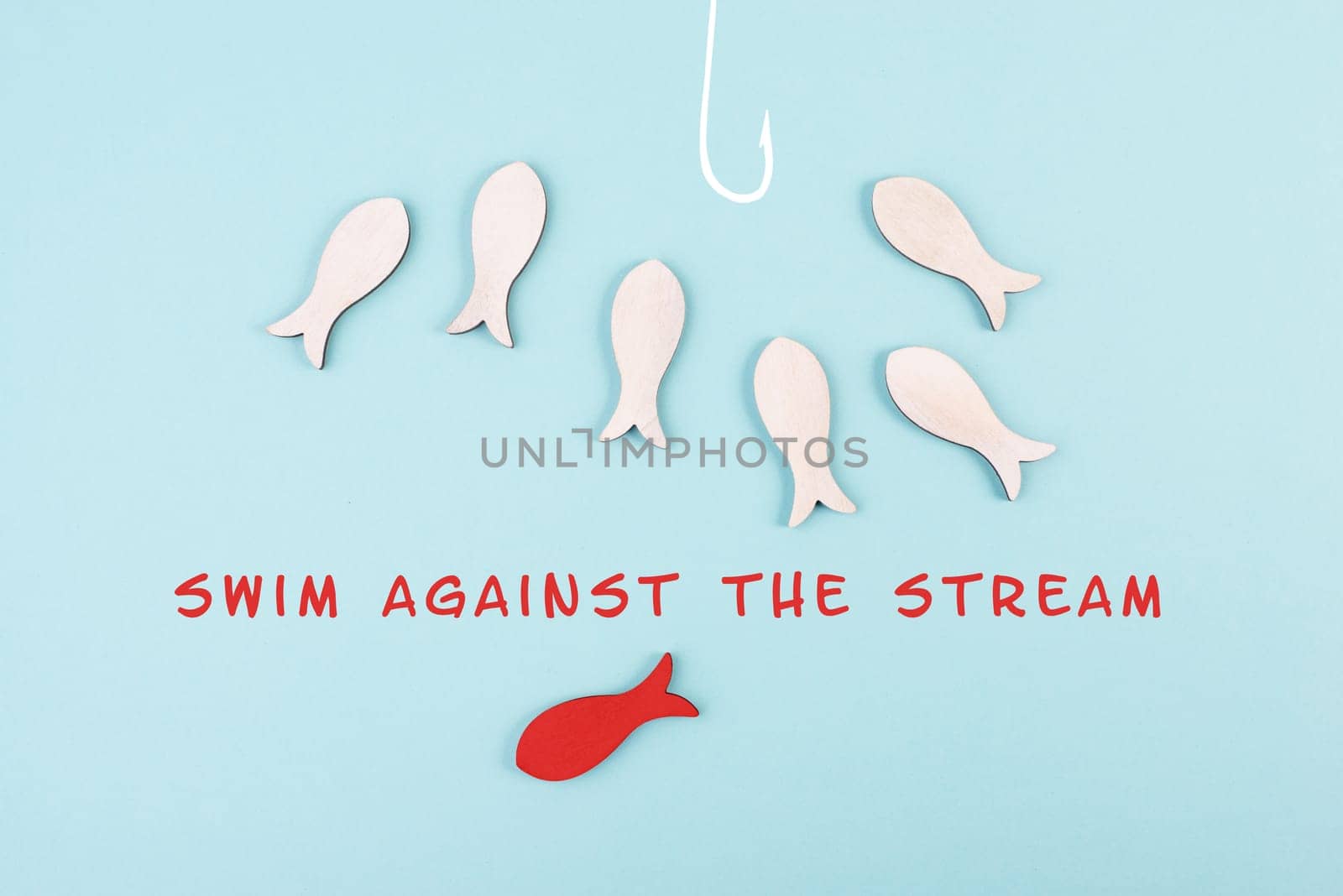 Group of fishes swimming to the fishing rod, red fish makes his own decision and takes a different direction, against the stream symbolic, courage and winner concept