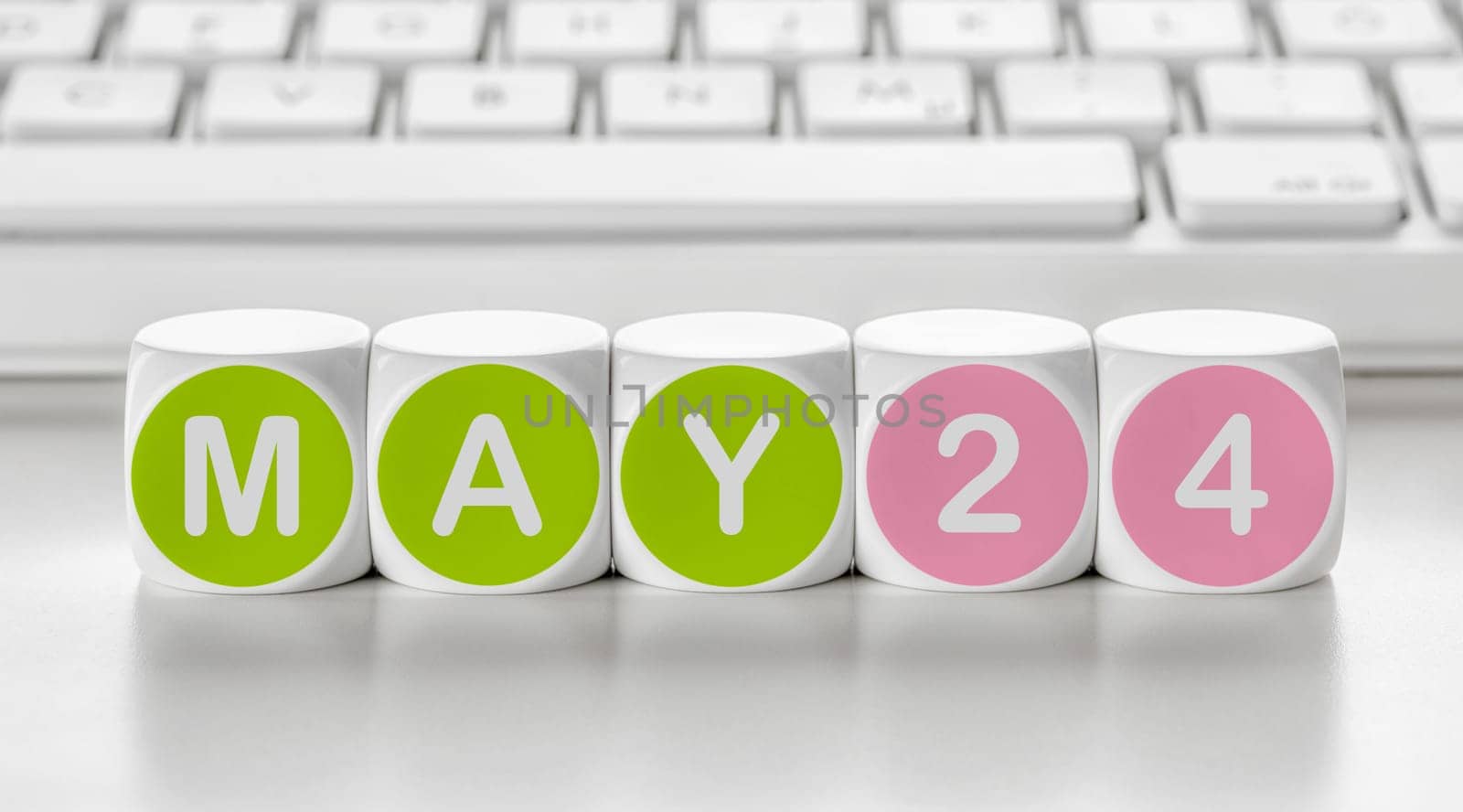 Letter dice in front of a keyboard - May 24