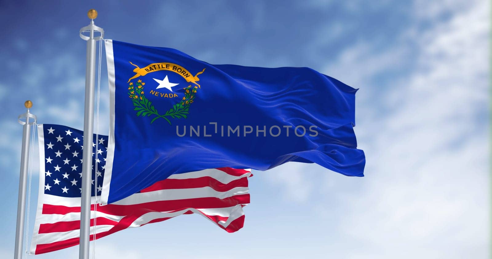 The Nevada state flag waving along with the national flag of the United States of America. In the background there is a clear sky. Nevada is a state in the Western region of the United States