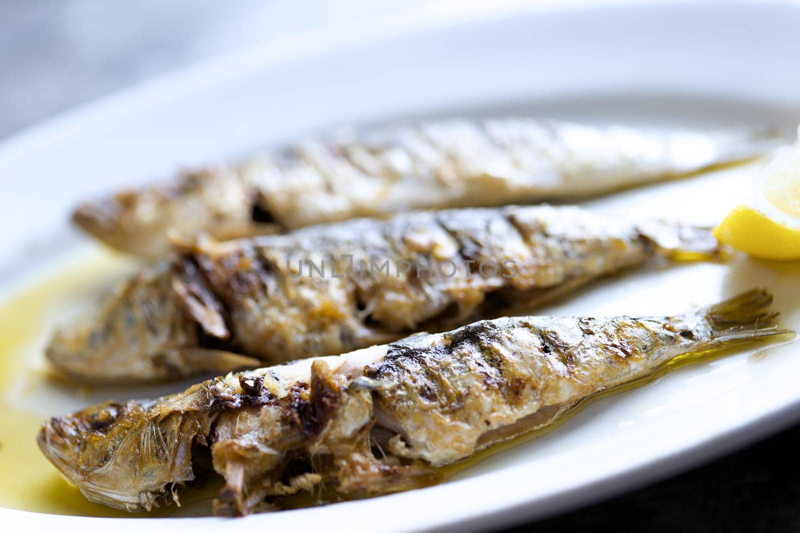 close up of plate of grilled sardines