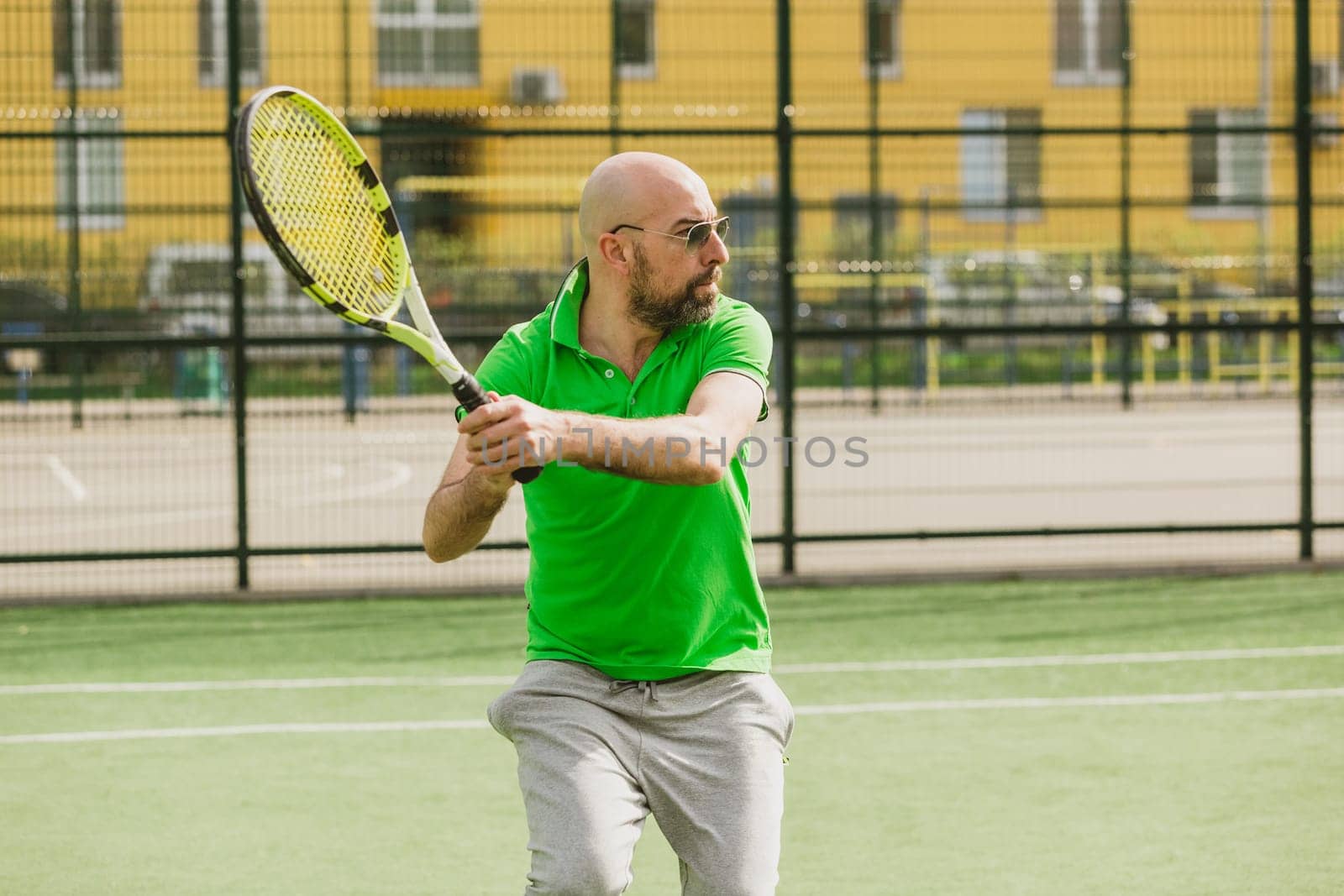 young man play tennis outdoor on tennis field at early morning