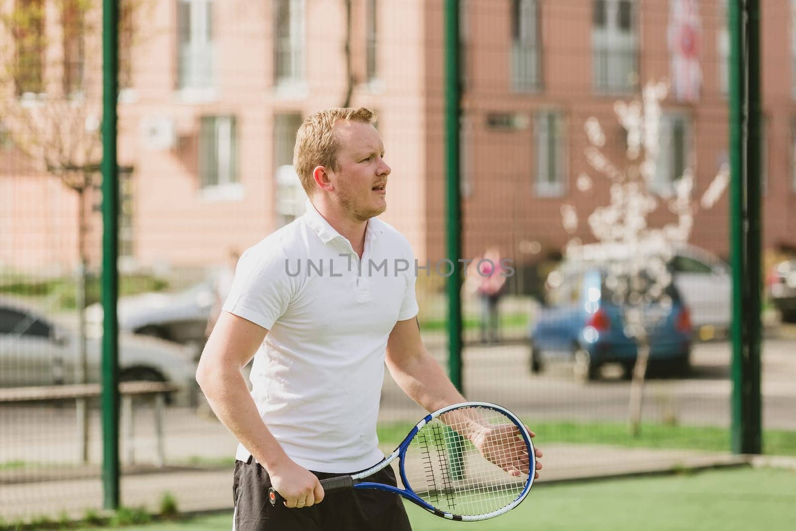 young man play tennis outdoor on tennis field at early morning