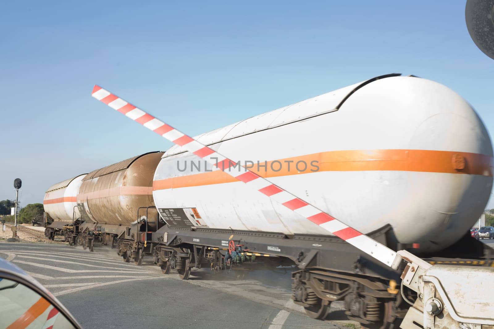 Merchandise wagon with oil tanks crossing on the road