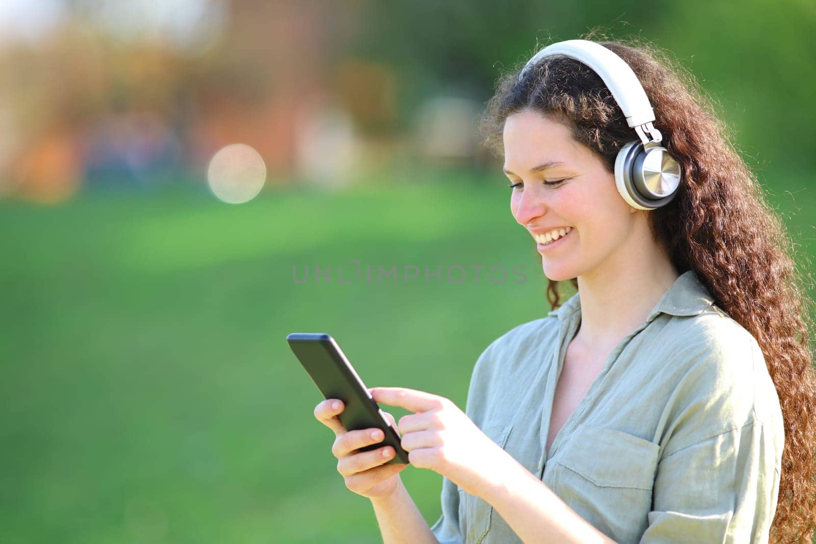 Happy woman listening to music checks smart phone