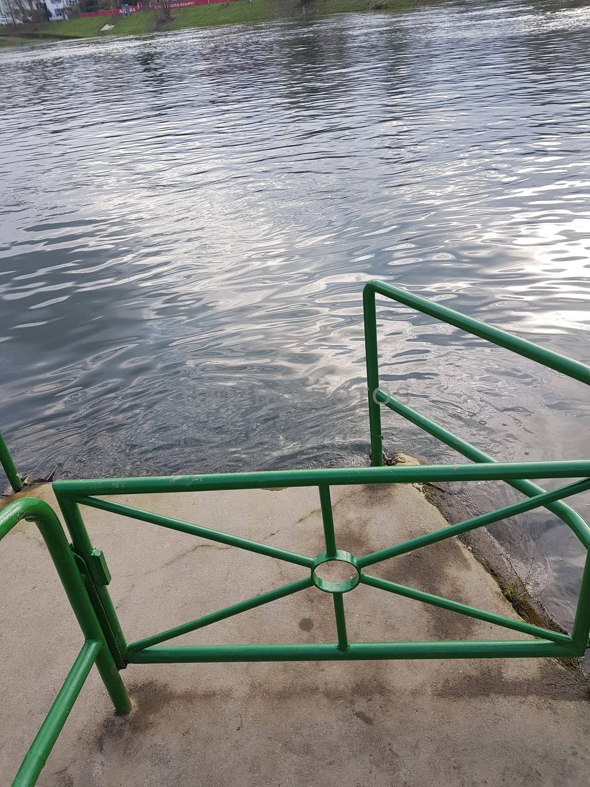 Flood on the river with a dock made of concrete