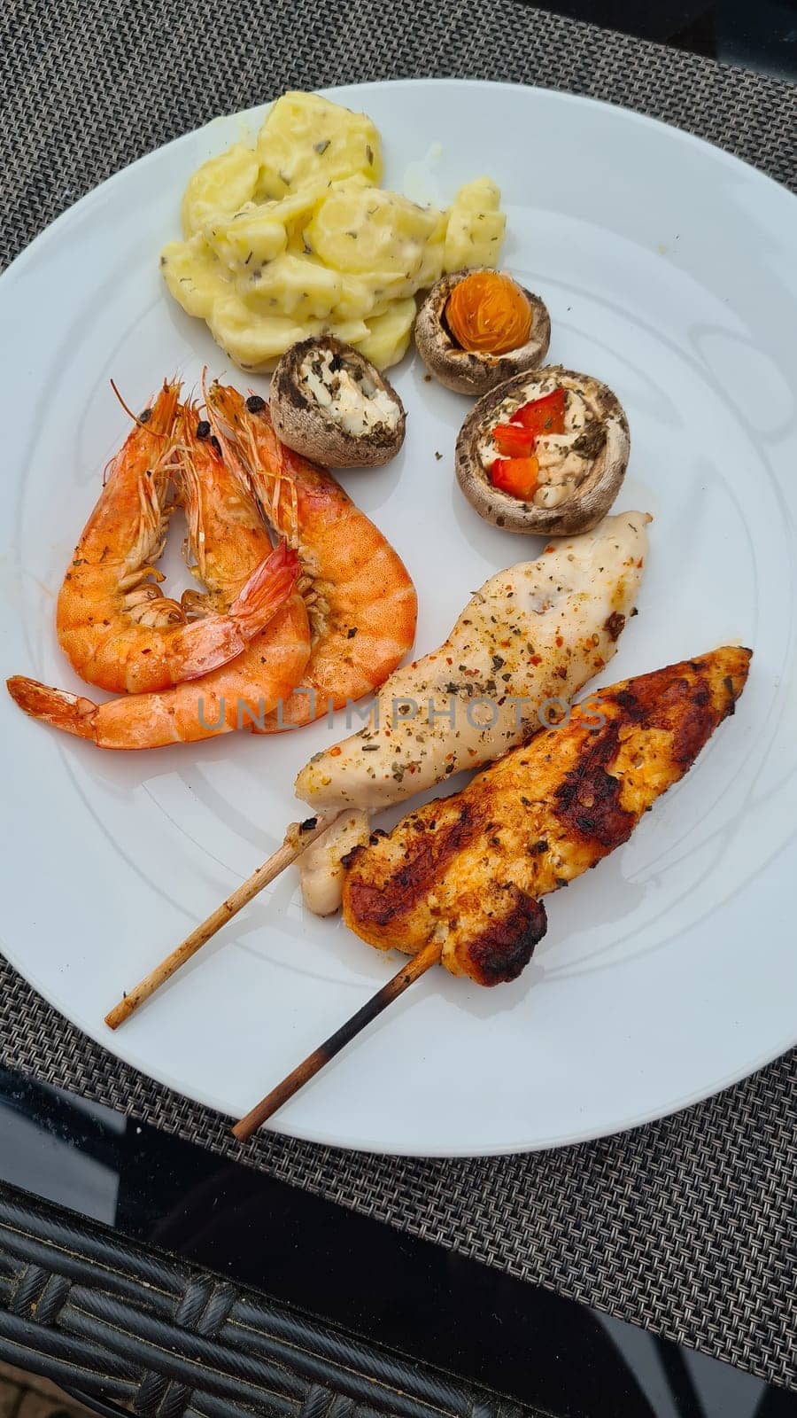 Grilled meat on wooden skewers on plate. Top view, lying flat