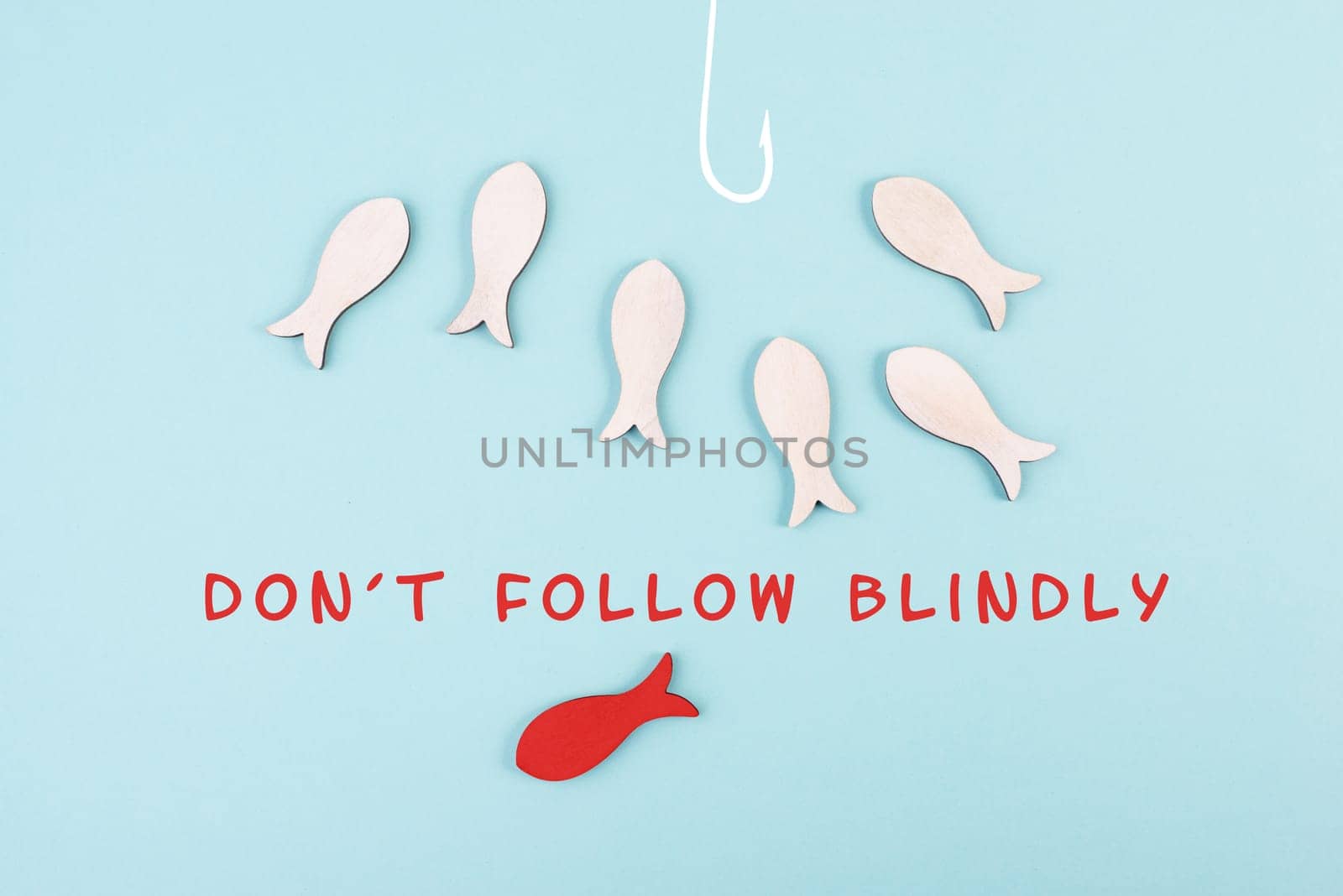 Group of fishes swimming to the fishing rod, red fish makes his own decision and takes a different direction, do not follow blindly, courage and winner concept