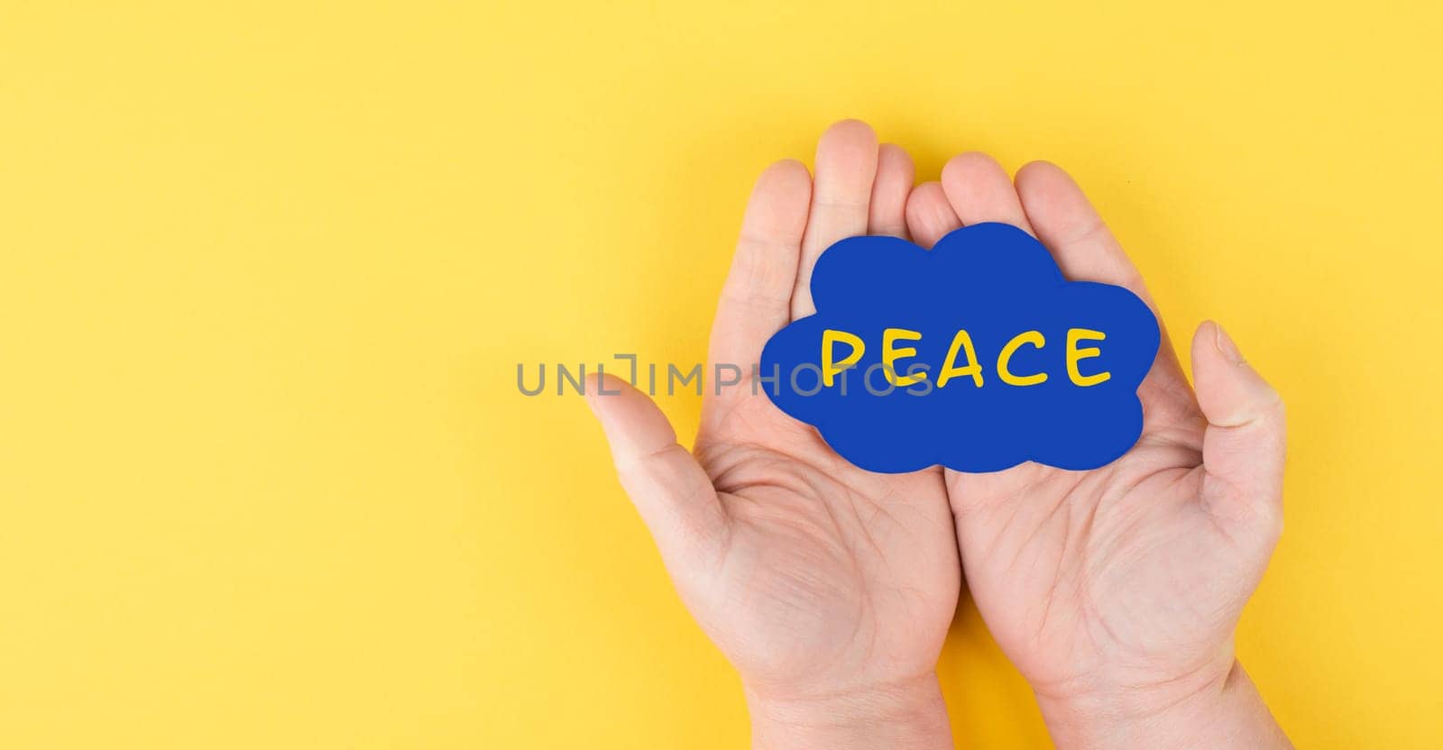 Holding a blue cloud with the word peace in the hands, stop war, support Ukraine, living peaceful together, color of ukrainian flag