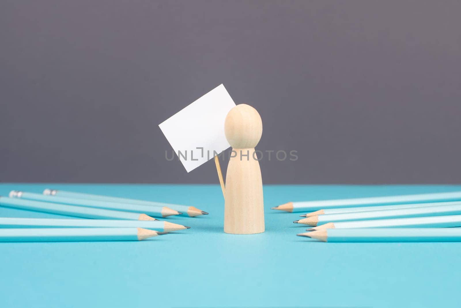 Man with an empty sign, blue pencils point to the person, business and education concept, cancel culture and free speech, journalist