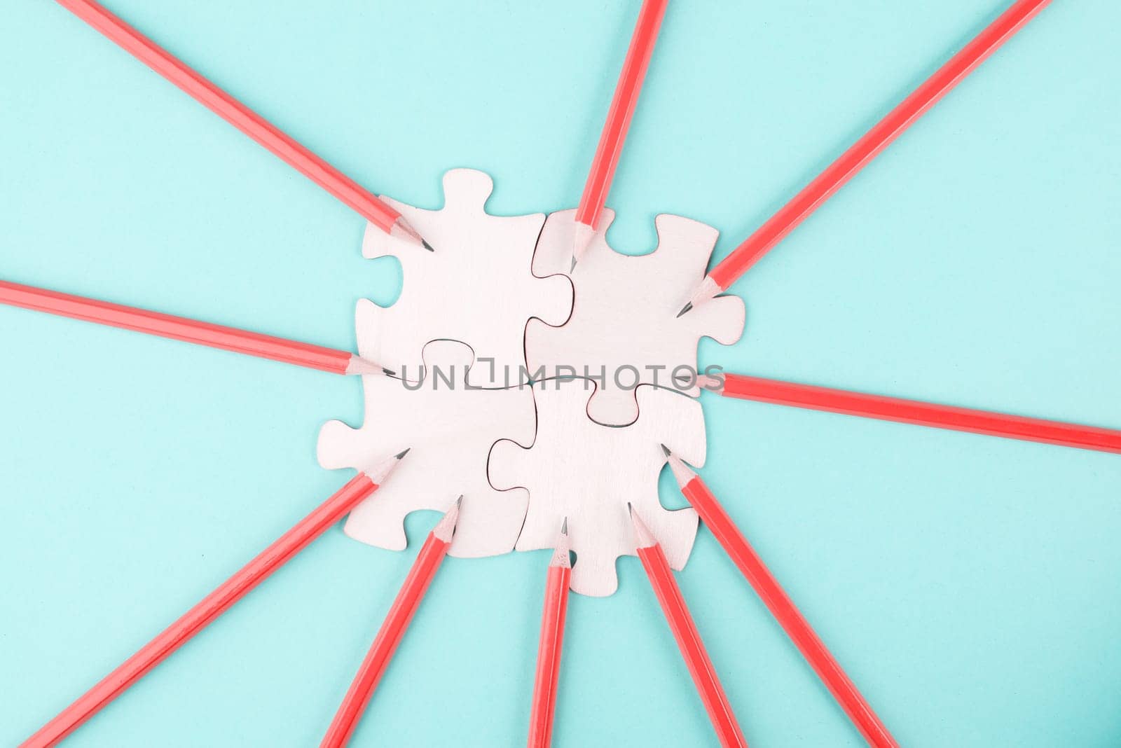 Working as a team, puzzle pieces connect together, pencils point to the jigsaw, brainstorming for ideas, business and education concept